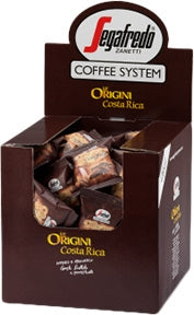 The Segafredo Zanetti Coffee System display box features individually packaged coffee pods labeled "Segafredo Costa Rica Single Origin Espresso Single-Serve Cartridges," renowned for their fruity and long-lasting flavor. Enjoy the rich taste of Costa Rica Single Origin Espresso with every brew from your Segafredo Espresso 1 Brewer.