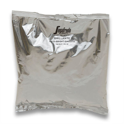 Segafredo Zanetti vacuum-sealed coffee bag with "Colombian Arabica - mild-bright-smooth" printed on it, reflecting light with visible wrinkles and seal lines.