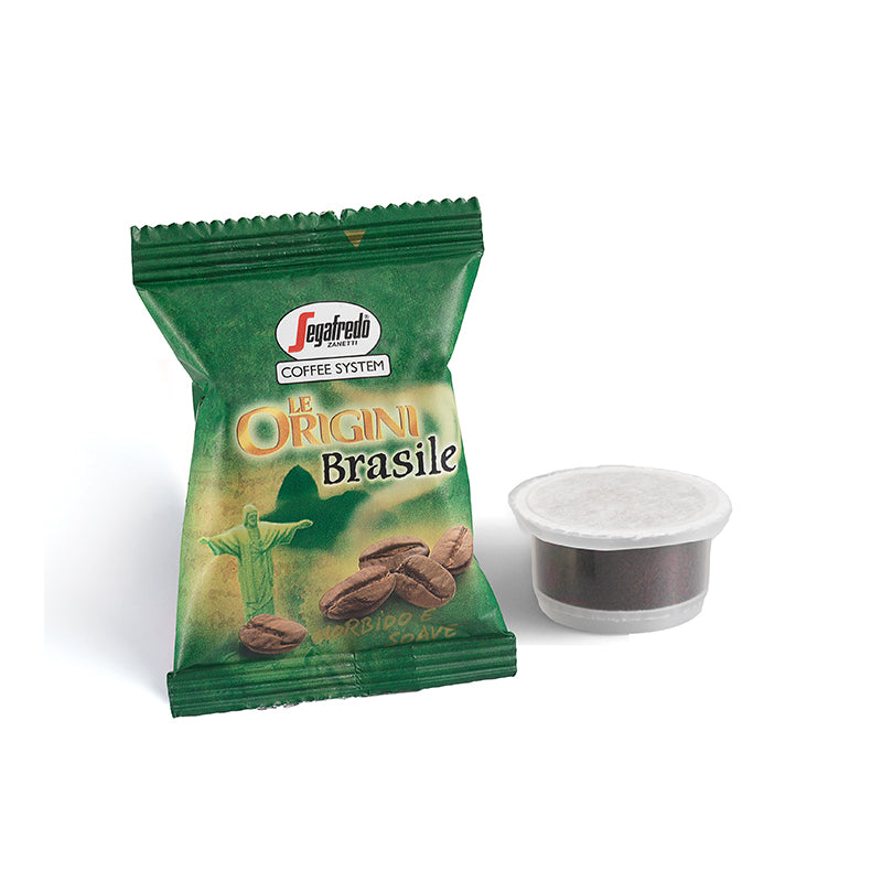 A green package of Segafredo Zanetti Brazilian Single Origin Espresso Single-Serve Cartridges, sourced from the Nossa Senhora da Guia plantation, sits next to a single-serve coffee pod.